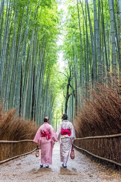 Foto asiatin, die japanischen kimono am arashiyama-bambuswald in kyoto, japan trägt