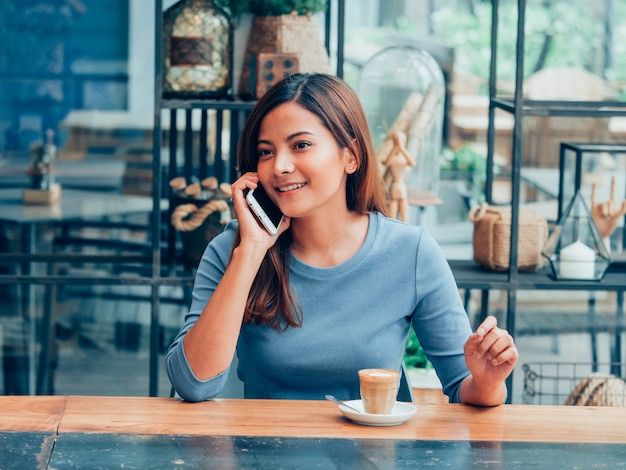 Asiatin, die Kaffee im Kaffeestubekaffee trinkt