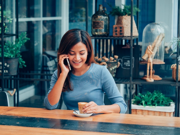 Asiatin, die Kaffee im Kaffeestubekaffee trinkt