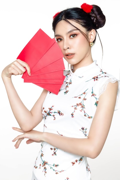 Asiatin, die traditionelles cheongsam qipao Kleid trägt, das angpao oder Geldgeschenk des roten Pakets hält