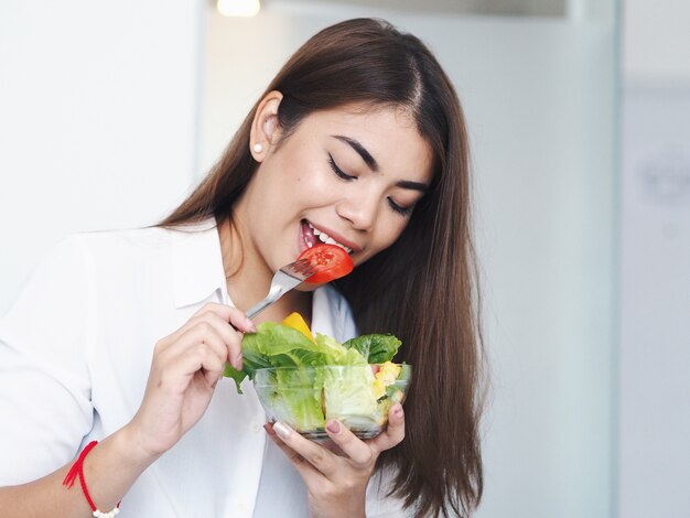 Asiatin froh mit frischem Salat