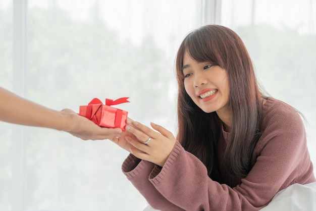 Asiatin glücklich, eine Geschenkbox zu erhalten