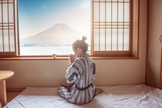 Asiatin trinkt grünen Tee mit Fuji-Berg, Japan-Art