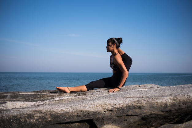 Asiatin üben Yoga am Strand