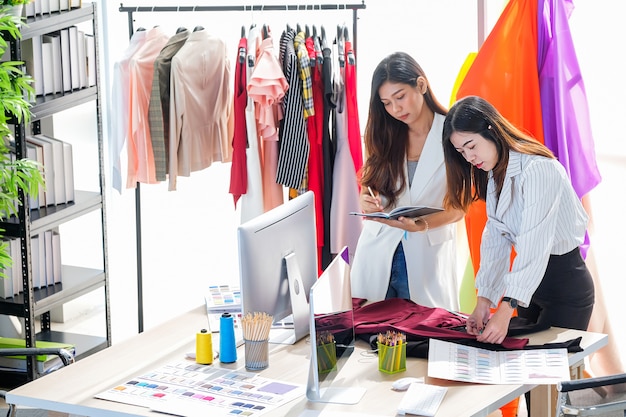 Asiatinnen bei der Arbeit sind Modedesigner und Schneider