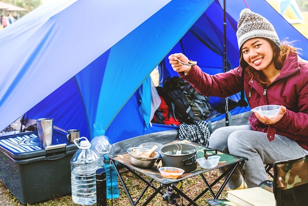 Asiatinreise entspannen sich im Feiertag. Camping auf dem Berg. sitzen frühstücken. Thailand