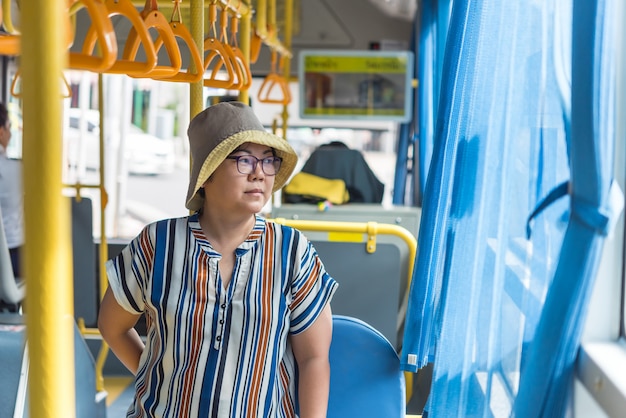 Asiatinreise mit dem Passagierbus in der Stadt