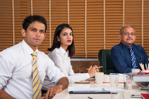 Asiatisch-indische Geschäftsleute oder Unternehmenskultur und Arbeiten im Bürokonzept mit Laptop, Papieren, Meetings, Präsentationen und Diskussionen