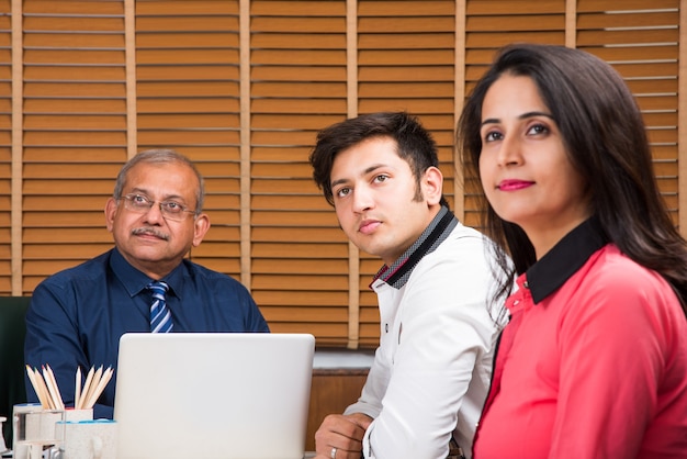 Asiatisch-indische Geschäftsleute oder Unternehmenskultur und Arbeiten im Bürokonzept mit Laptop, Papieren, Meetings, Präsentationen und Diskussionen