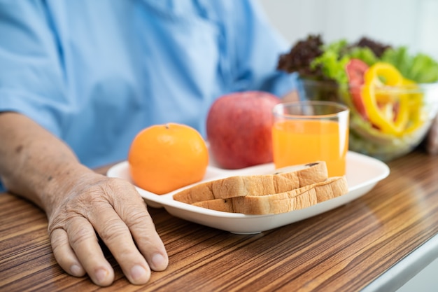 asiatische ältere Frau Patient, die Frühstück Gemüse gesundes Essen isst