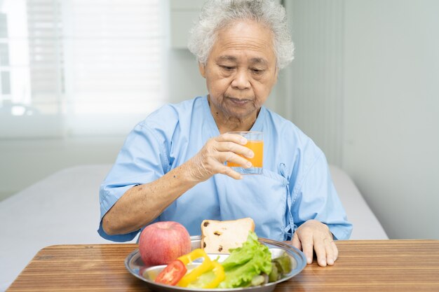 asiatische ältere Frau Patient, die Frühstück Gemüse gesundes Essen isst