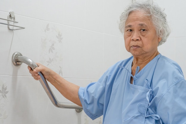 Asiatische ältere Frau Patient verwenden Toilette Badezimmergriff Sicherheit.