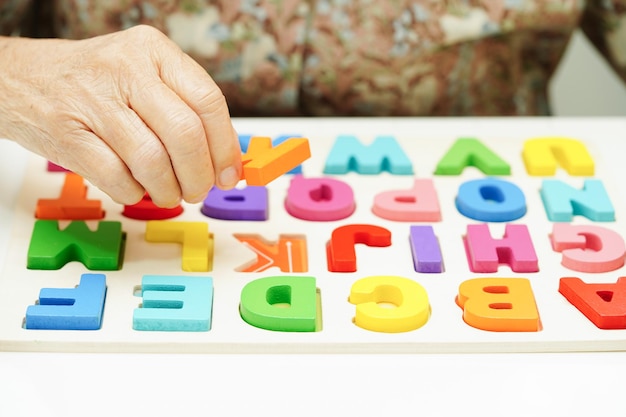 Asiatische ältere Frau spielt ein Puzzle-Spiel zur Behandlung, Prävention von Demenz und Alzheimer-Krankheit
