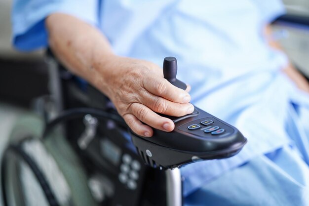 Foto asiatische ältere oder ältere alte dame patientin im elektrischen rollstuhl mit fernbedienung auf der krankenhausstation gesundes starkes medizinisches konzept