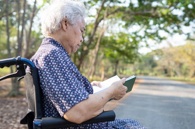 Foto asiatische ältere oder ältere alte dame patientin liest ein buch, während sie auf dem bett in der krankenhausstation sitzt gesundes starkes medizinisches konzept