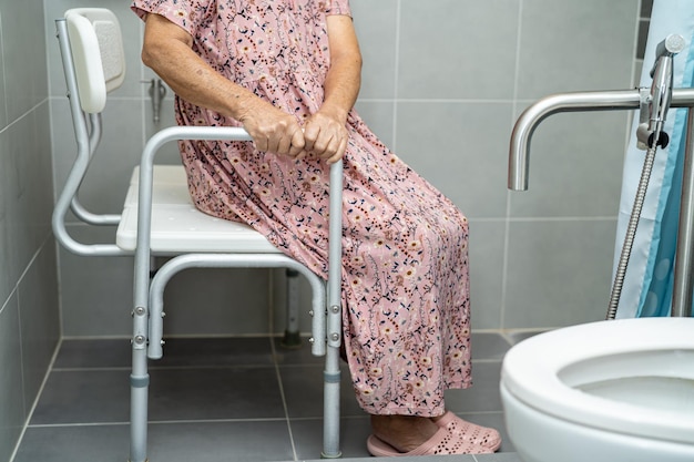 Asiatische ältere oder ältere alte damenpatienten verwenden wc-badezimmergriffsicherheit in der pflegekrankenstation gesundes starkes medizinisches konzept