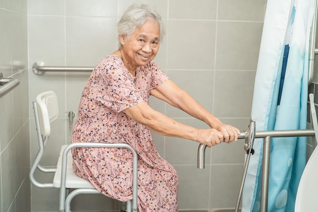 Asiatische ältere oder ältere alte damenpatienten verwenden wc-badezimmergriffsicherheit in der pflegekrankenstation gesundes starkes medizinisches konzept