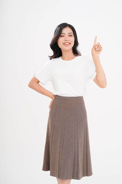 Asiatische attraktive schöne junge Frau mit der Handgeste, die mit dem Finger auf dem Kopienraum lokalisiert auf Hintergrund zeigt