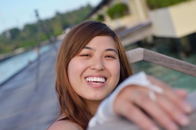 Foto asiatische braut mit schleier am strand im himmel und im blauen meer. flitterwochen auf der fantastischen insel im sommer