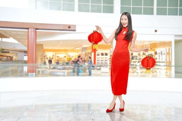 Asiatische Chinesin in einem cheongsam Kleid, das chinesische Laterne hält