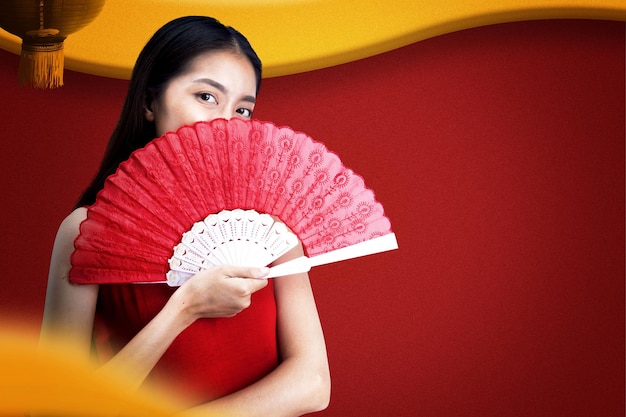 Asiatische Chinesin in einem Cheongsam-Kleid mit Fächer feiert das chinesische Neujahr. Frohes chinesisches Neujahr