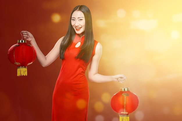 Asiatische chinesische Frau in einem cheongsam Kleid, das chinesische Laterne hält. Frohes chinesisches Neujahr