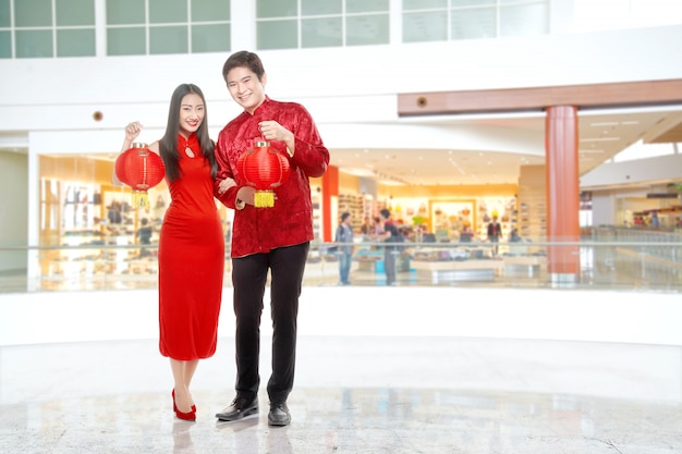 Asiatische chinesische Paare im cheongsam Kleid, das chinesische Laterne hält