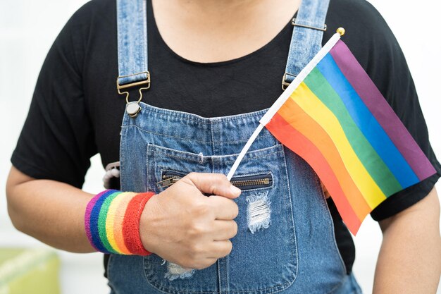 Foto asiatische dame hält eine lgbti-flagge in regenbogenfarben