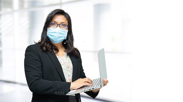 Asiatische Dame mit Maske neu normal im Amt zum Schutz der Sicherheitsinfektion Covid-19 Coronavirus.