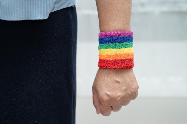 Foto asiatische dame mit regenbogenfahnen-armbändern, symbol des lgbt-stolzmonats, feiert jährlich im juni die sozialen rechte von schwul-lesbischen bisexuellen transgendern