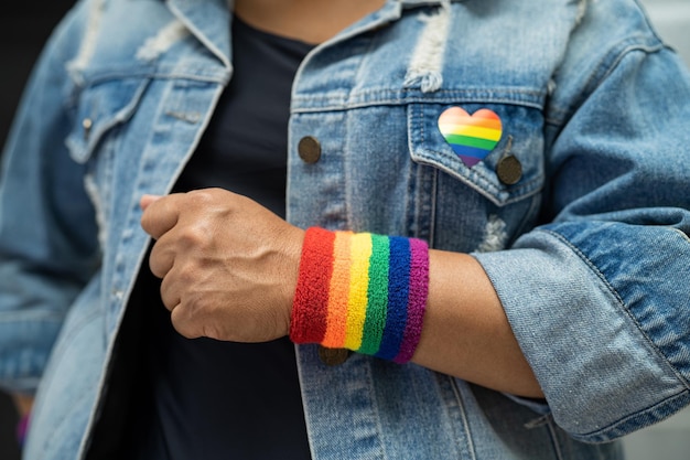 Asiatische Dame mit Regenbogenfahnen-Armbändern, Symbol des LGBT-Stolzmonats, feiert jährlich im Juni die sozialen Rechte von schwul-lesbischen bisexuellen Transgendern