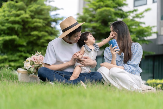 Asiatische Eltern und ein Kind spielen zu Hause im Garten. Familienkonzept.