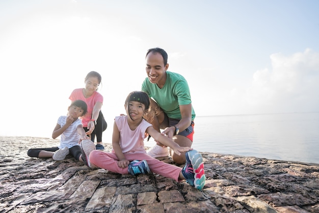 Asiatische Eltern und Kinder treiben Sport im Freien