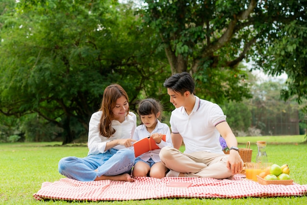 Asiatische Familie, die ein Picknick im Park hat