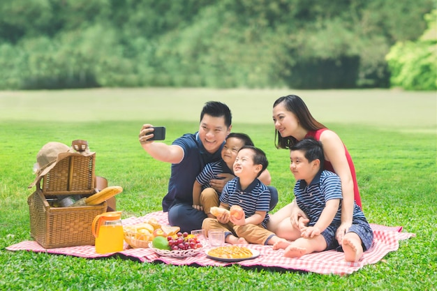 Asiatische Familie macht ein Foto im Park