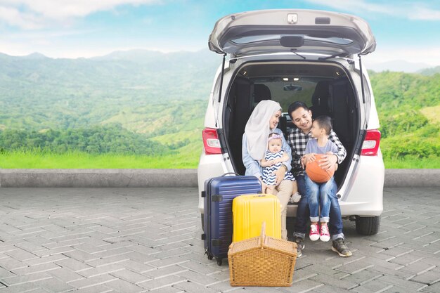 Asiatische Familie mit Auto im Berg