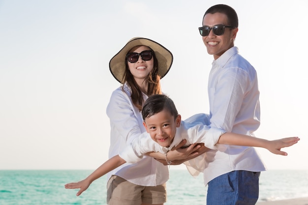 Asiatische Familie spielt am Strand