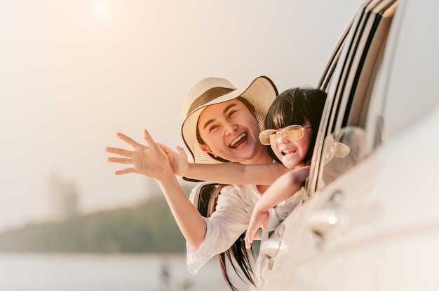 Asiatische FamilienurlaubsferienGlückliche Familieneltern, die Kinder halten, die in den Himmel fliegen