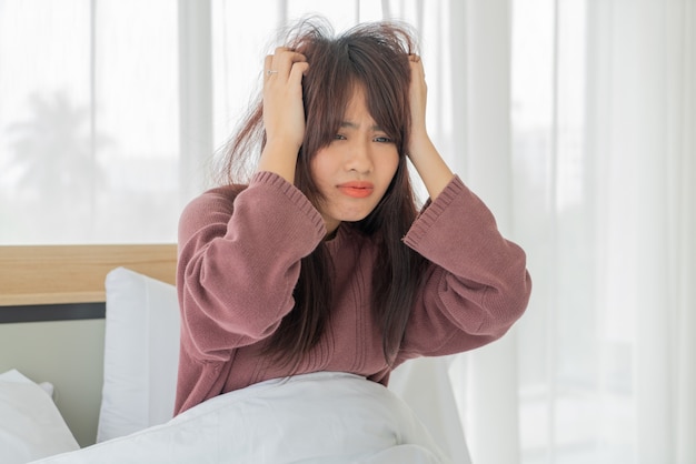 Asiatische Frau belasten und ernst auf dem Bett