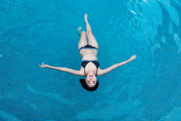 Asiatische Frau der glücklichen Berufung entspannen sich auf dem Wasserschwimmbad