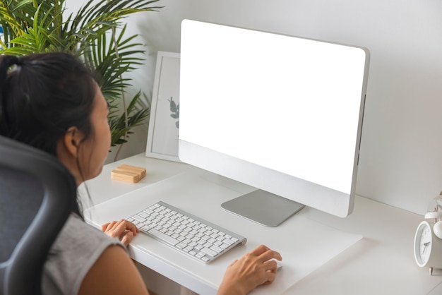 Asiatische Frau des Büroangestellten der Nahaufnahme, die zu Hause auf dem weißen Bildschirm des Tastaturcomputers schreibt Konzept der Technologieverbindungskommunikation Beschneidungspfad auf dem weißen Bildschirm isoliert