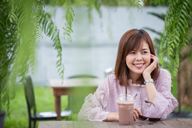 Foto asiatische frau des porträts, die in der kaffeestube lächelt.