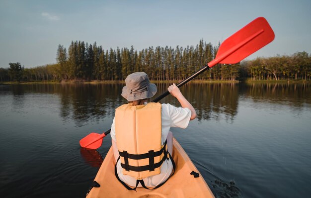 Asiatische Frau, die allein auf See Kajak fährt. Sommercamp und Solo-Aktivität im Freien