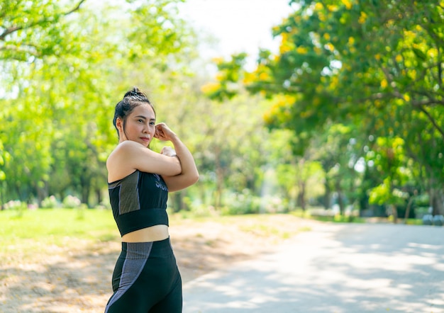 Asiatische Frau, die am Park ausdehnt