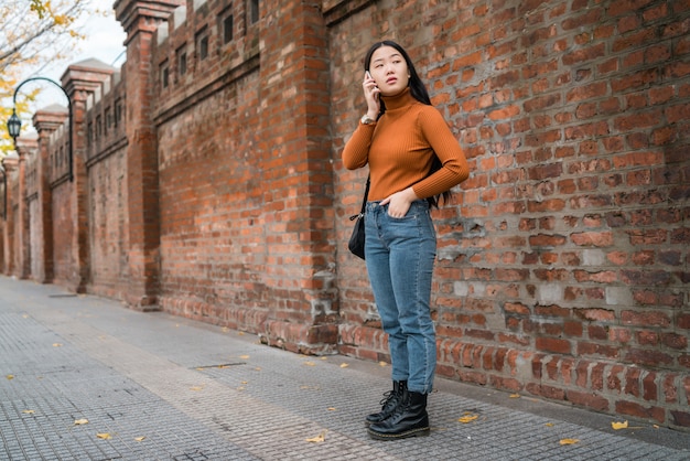 Asiatische Frau, die am Telefon spricht.