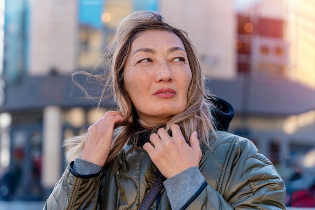 Asiatische Frau, die auf der Straße spazieren geht und ein süßes, trendiges Outfit trägt