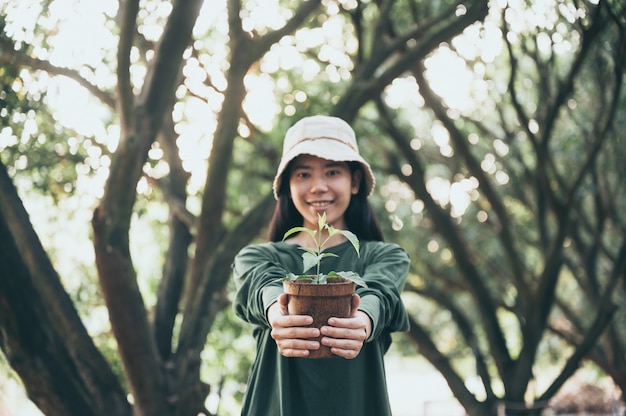 Asiatische Frau, die Bäume für die Umwelt pflanzt