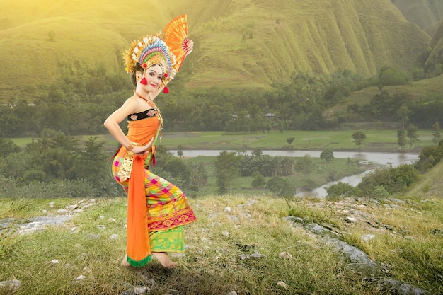 Asiatische Frau, die balinesischen traditionellen Tanz (Kembang Girang Tanz) auf dem Feld tanzt