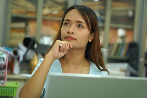 Asiatische Frau, die Computerarbeitsplan analysiert