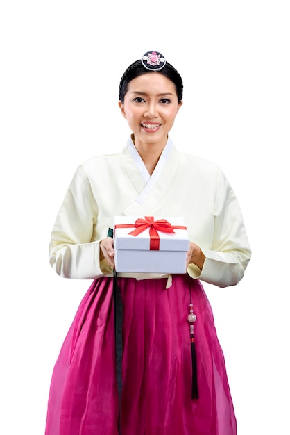 Asiatische Frau, die ein traditionelles koreanisches Nationalkostüm Hanbok trägt, während sie eine Geschenkbox hält